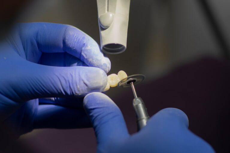 A dentist showing a dental implant model to an adult patient seated in a dental clinic.